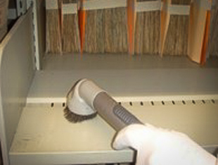 Nettoyage des rayonnages à l'aide d'un aspirateur muni de filtres de haute performance (HEPA)